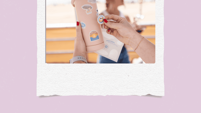 Girl putting stickers on a water bottle